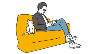 ソファーに座って本を読んでいる男性
